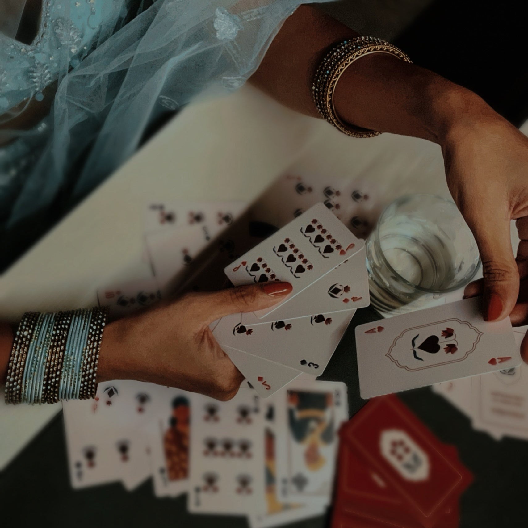 Close-up of hands playing cards with a focus on the cards and hands.