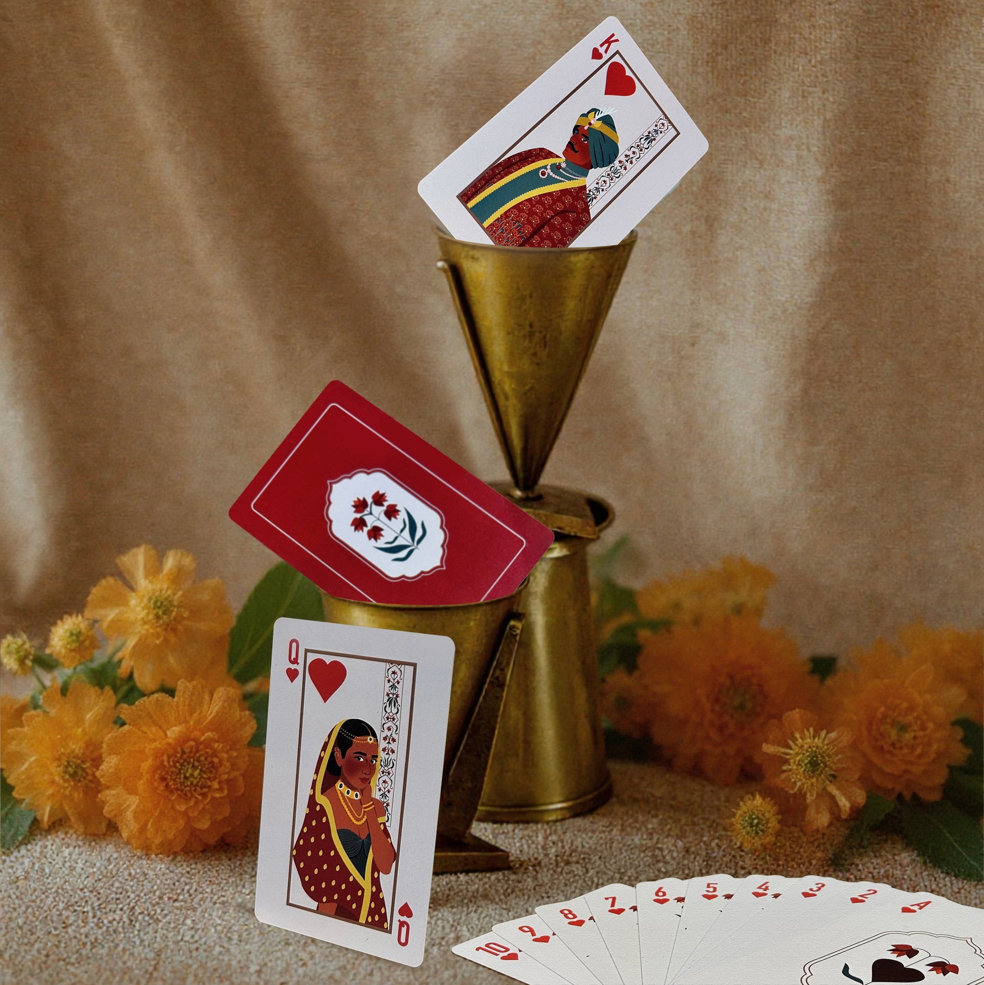 Playing cards with decorative designs on a textured surface with flowers