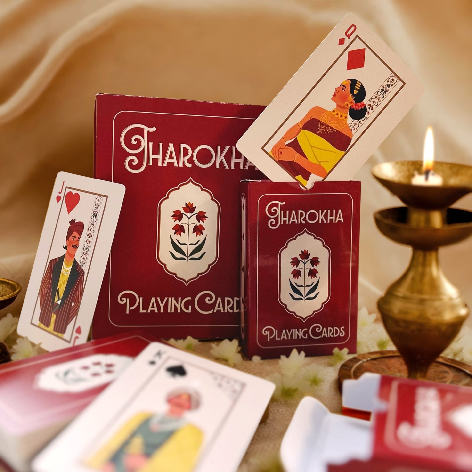 Jharokha playing cards with cards and a candle on a decorative surface