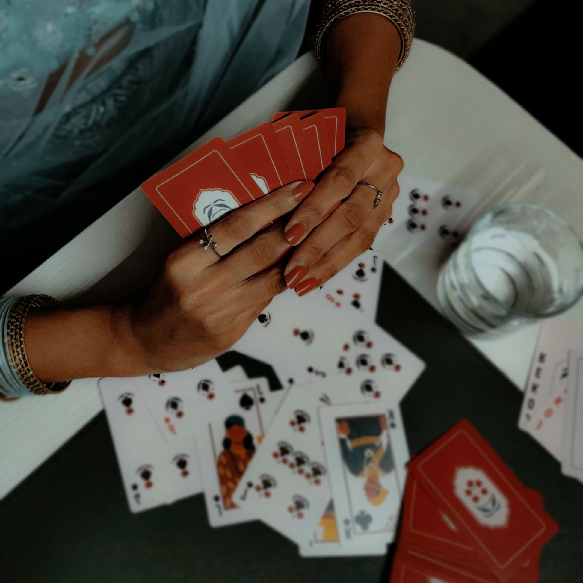 Hand holding playing cards at a diwali party.