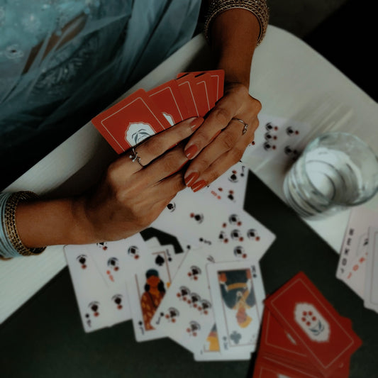 Hand holding playing cards at a diwali party.